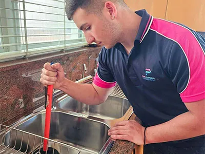Pink Plumbing plumber clearing a blocked kitchen sink