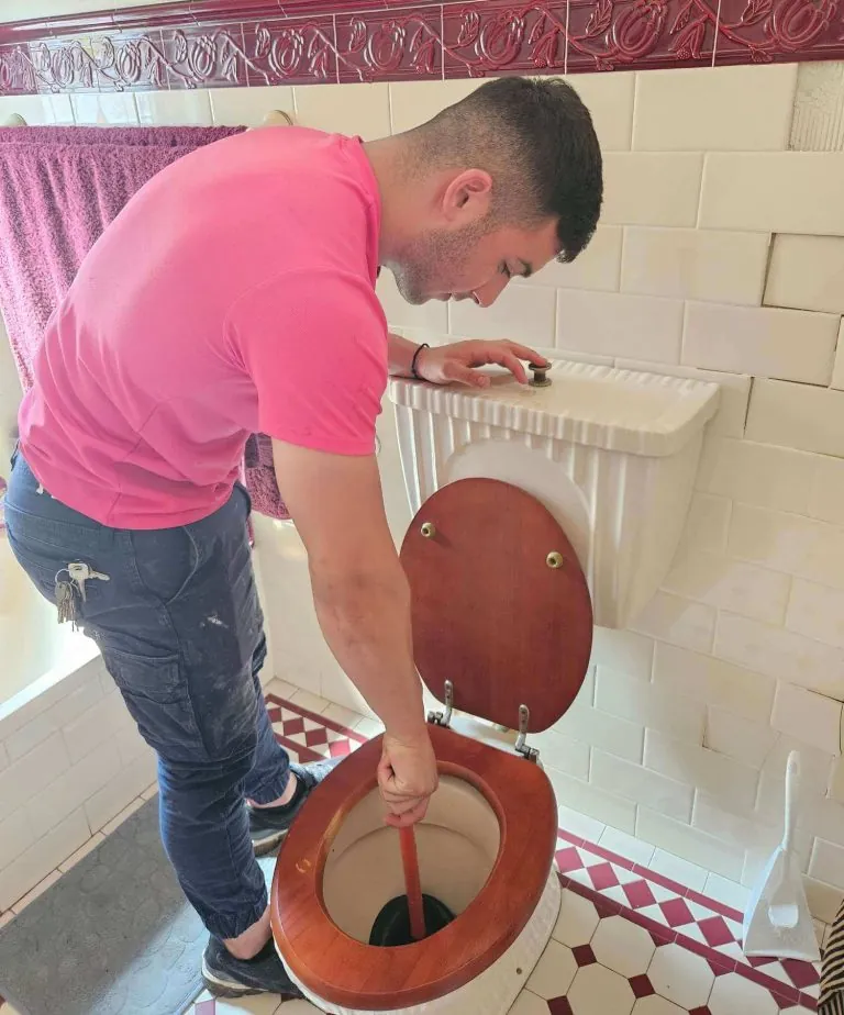 Pink Plumbing plumber repairing an overflowing toilet