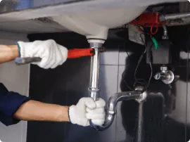 Plumber tightening a pipe