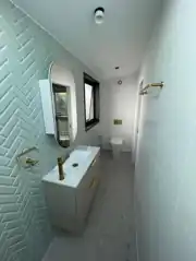 Bathroom fit-off with brass tapware and herringbone tiles